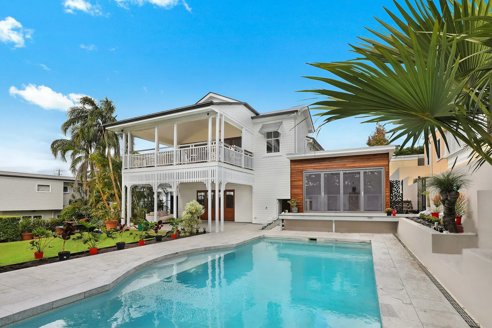 A large executive home with a tiled roof and mature landscaping in a gated community